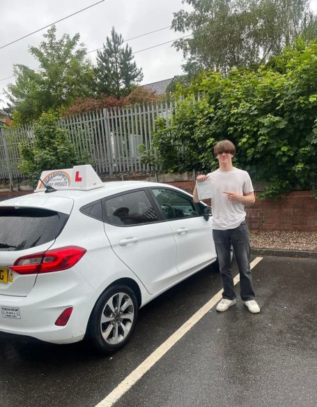Pupil standing beside the driving school car